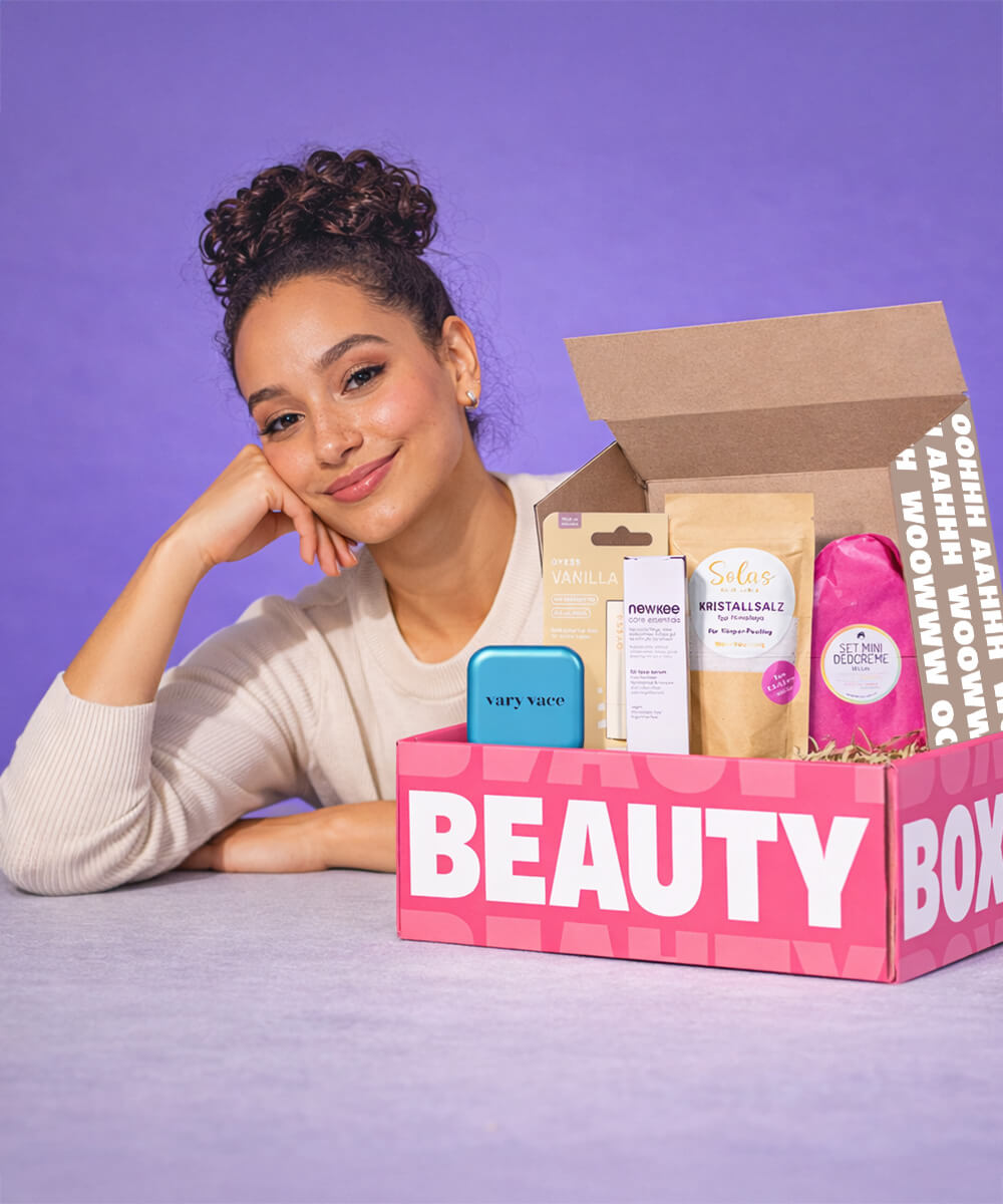 Frau mit Beautybox vor lila Hintergrund