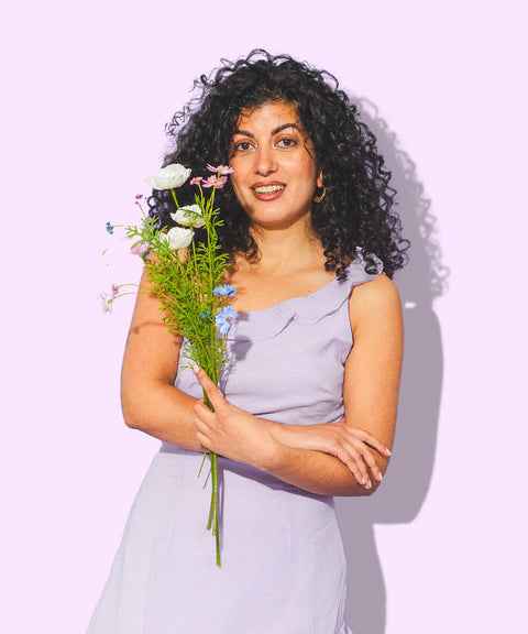 Frau mit Blumen vor rosa Hintergrund