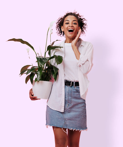 Frau mit Pflanze vor rosa Hintergrund