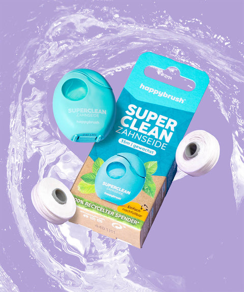 happy brush zahnseide mit wasser und verpackung auf lila hintergrund