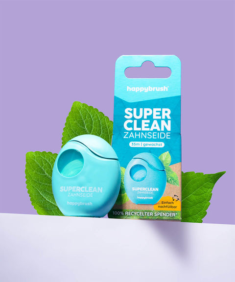 Zahnseide Verpackung und Produkt mit Blätter im Hintergrund 