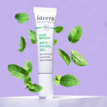 Lavera Anti Pickel Gel steht auf erhöhung mit Minzblättern in der Luft