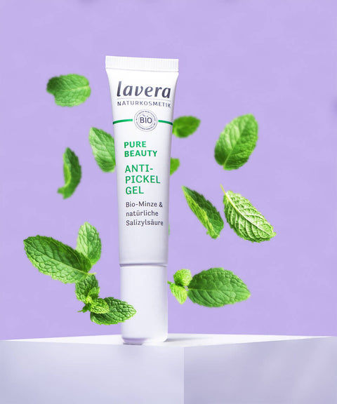 Lavera Anti Pickel Gel steht auf erhöhung mit Minzblättern in der Luft