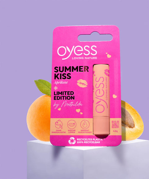 oyess Lipbalm Aprikose auf weißen Kasten mit Aprikosen dahinter